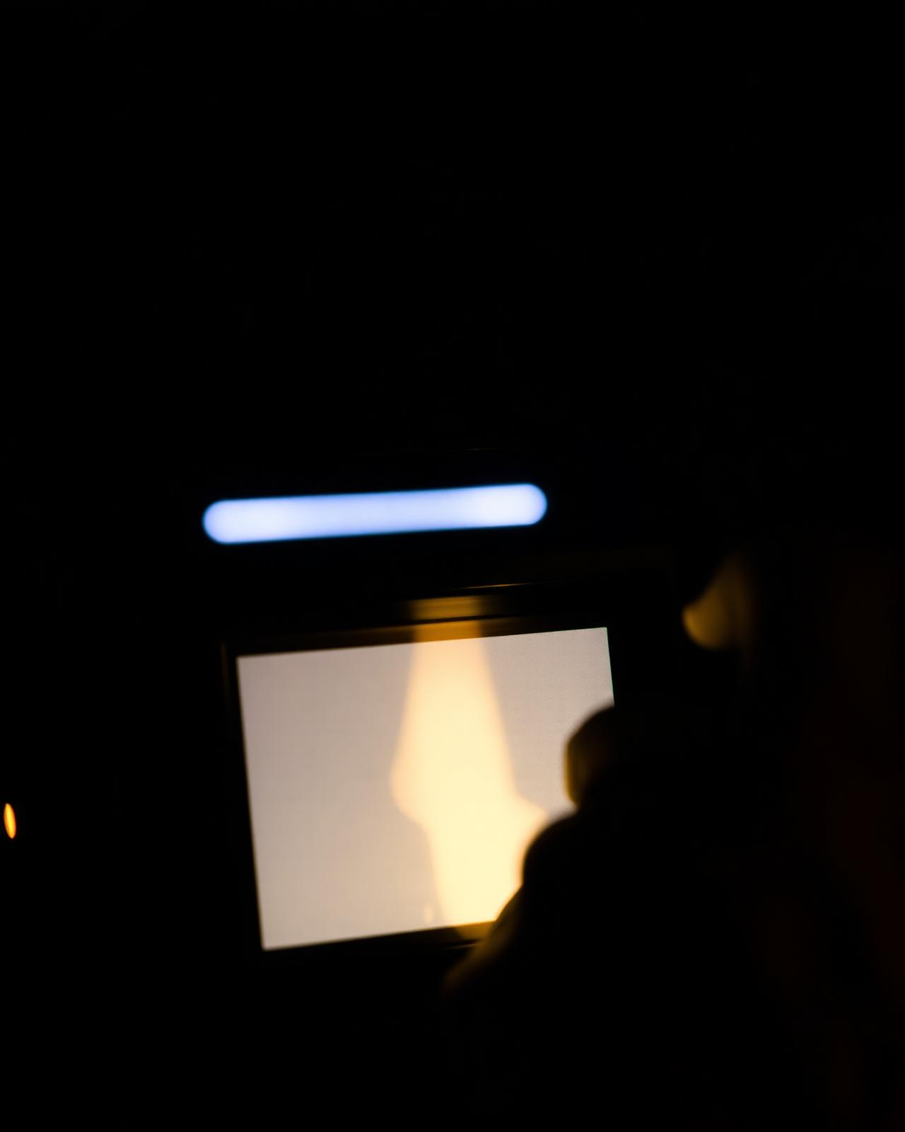 Placeholder frame: glowing camera monitor in a dark workspace
